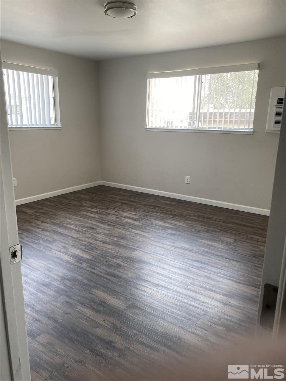 1365 Stardust Street, Unit 3 Reno, NV 89503 - Photo 6 of 9 an empty room with wooden floor and windows