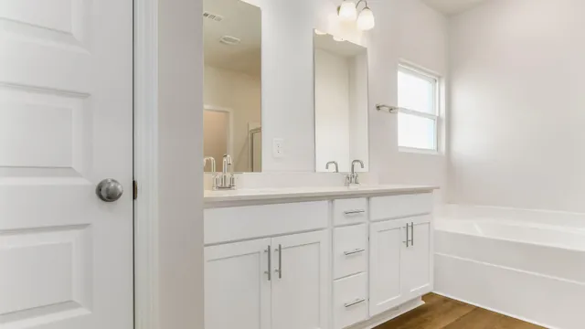 a bathroom with a tub sink and mirror
