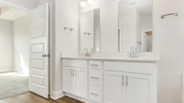 a bathroom with white cabinets and sink