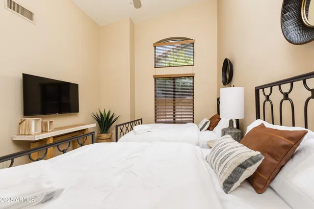 a bedroom with a bed and a flat screen tv