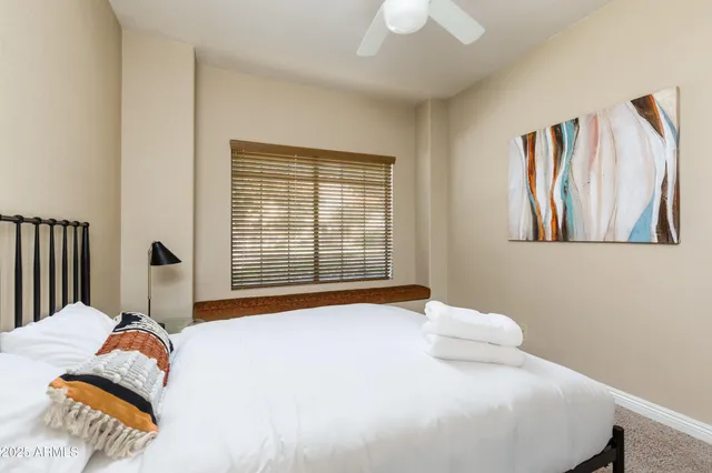 a bedroom with a bed and a painting on the wall