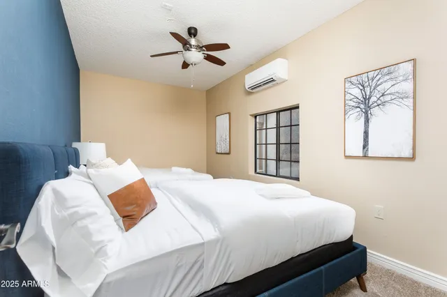 a bedroom with a large bed and a chandelier