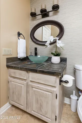 a bathroom with a granite countertop toilet and sink