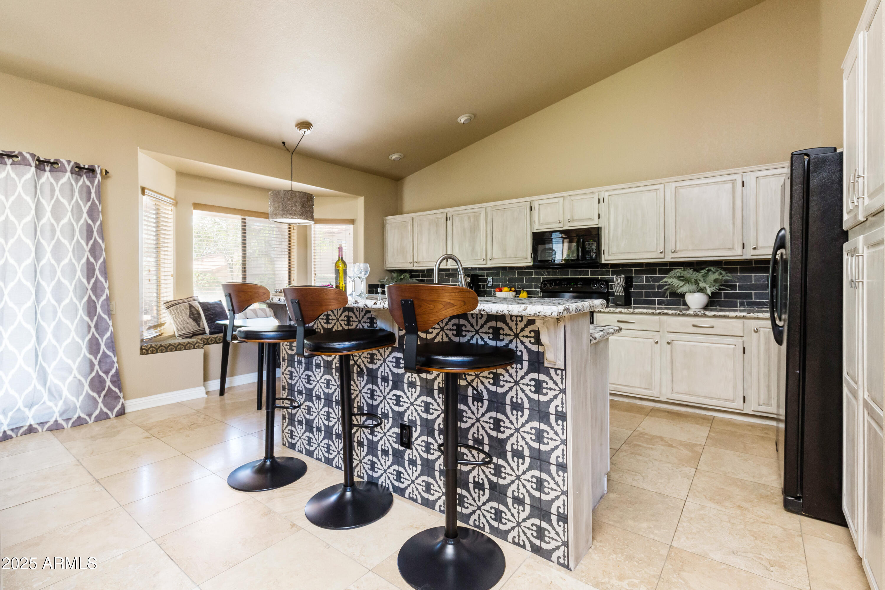 5821 East Aire Libre Avenue Scottsdale, AZ 85254 - Photo 8 of 35 a kitchen with stainless steel appliances kitchen island granite countertop a sink dishwasher a stove a refrigerator a microwave oven with a dining table and chairs