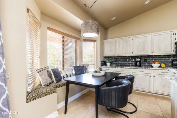 a kitchen with a table chairs and white cabinets