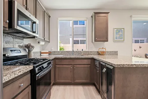 a kitchen with stainless steel appliances granite countertop a stove and a sink