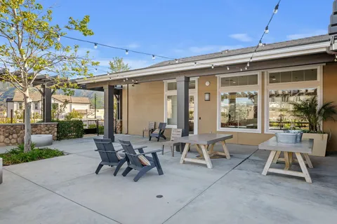 a dining room with wooden floor a glass table and chairs