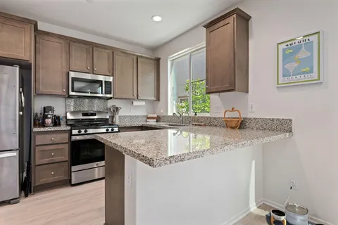 a kitchen with stainless steel appliances granite countertop a sink stove and microwave