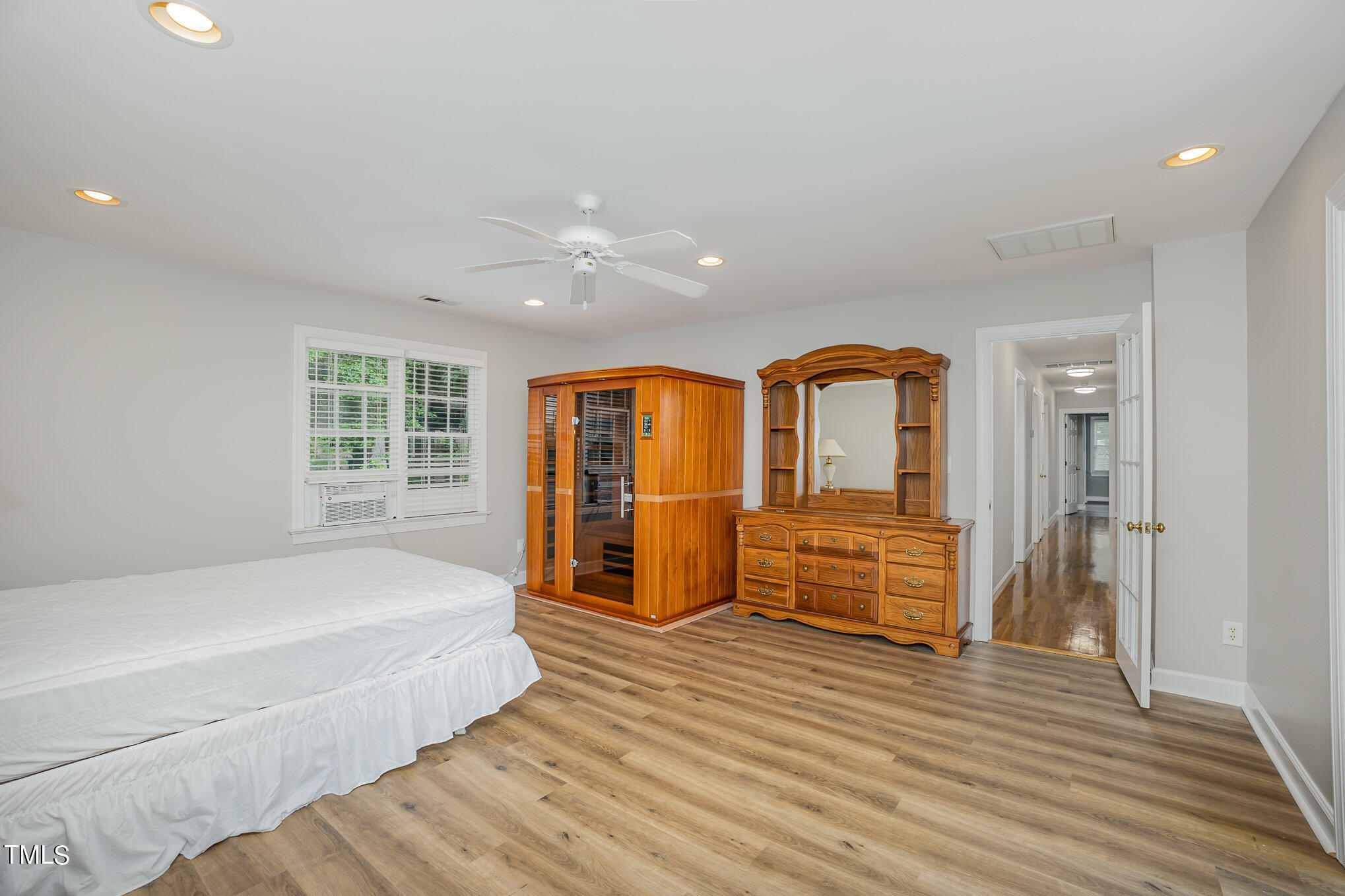 9400 Floral Ridge Court Raleigh, NC 27613 - Photo 25 of 35 a spacious bedroom with a bed and wooden floor
