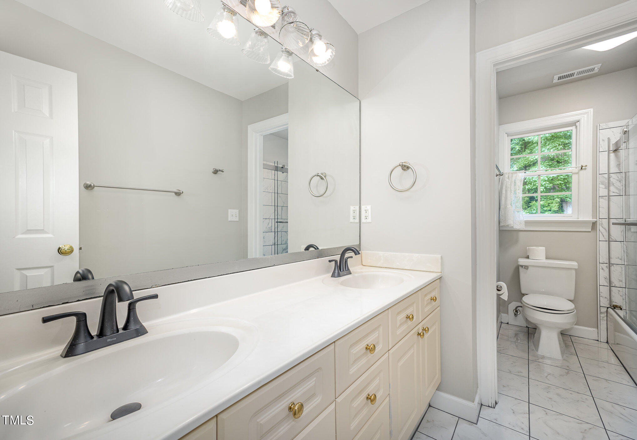 9400 Floral Ridge Court Raleigh, NC 27613 - Photo 27 of 35 a spacious bathroom with a granite countertop sink a toilet and a mirror