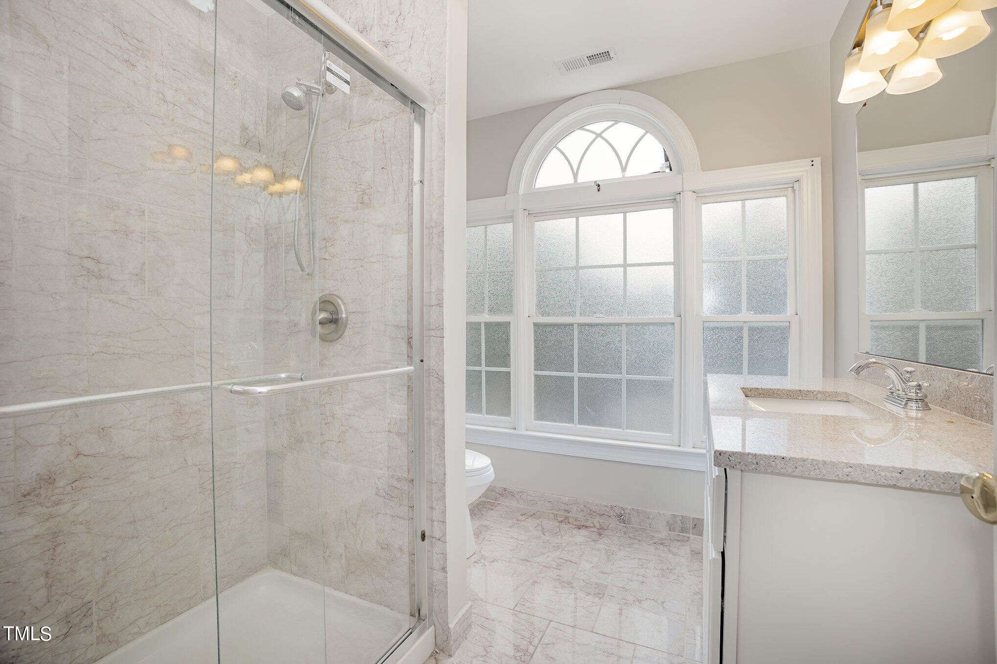 9400 Floral Ridge Court Raleigh, NC 27613 - Photo 28 of 35 a bathroom with a granite countertop sink a large mirror and a shower