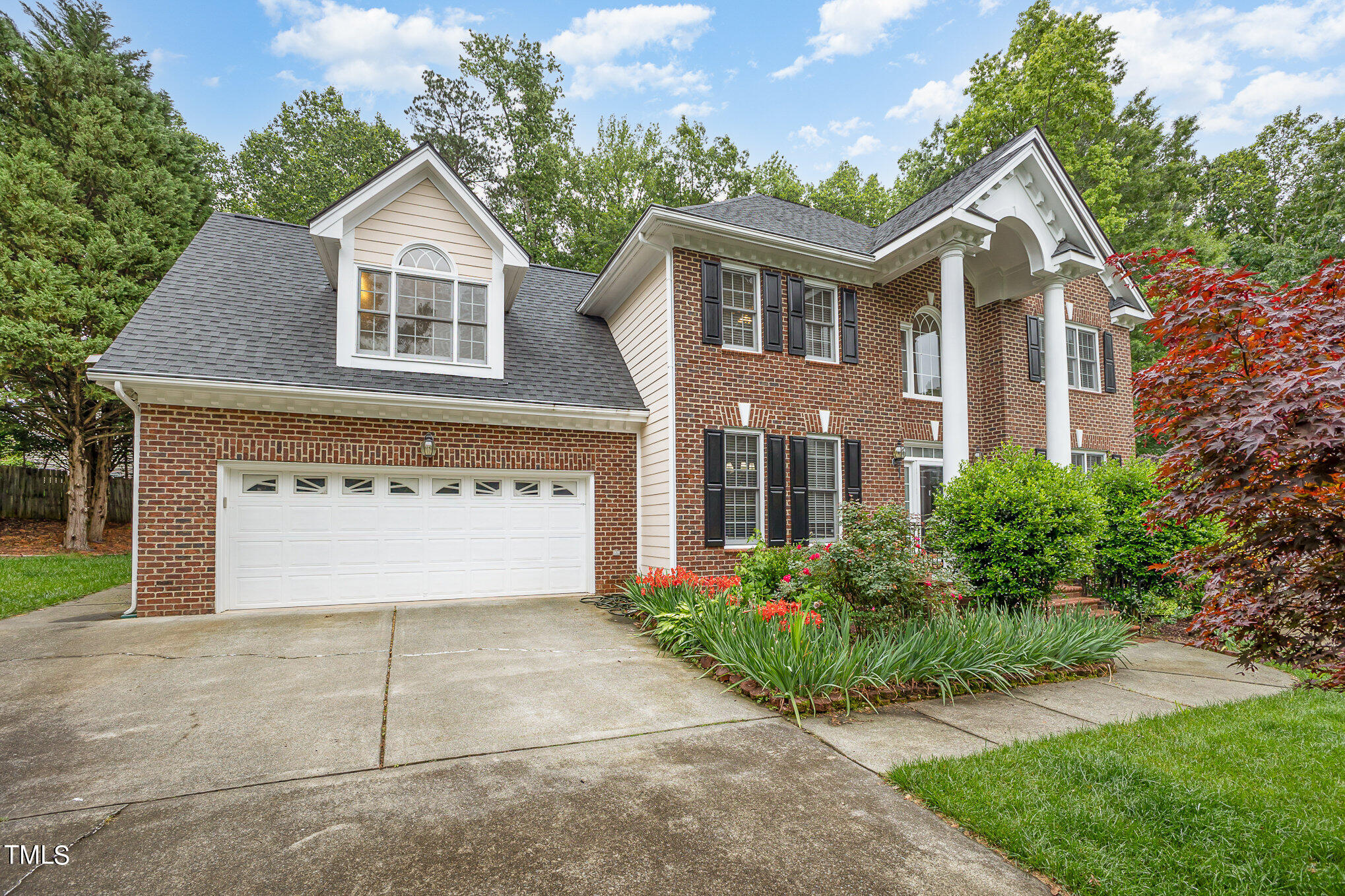 9400 Floral Ridge Court Raleigh, NC 27613 - Photo 3 of 35 a front view of a house with a yard and garage
