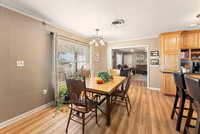 a kitchen with stainless steel appliances granite countertop a refrigerator a stove and white cabinets with wooden floor