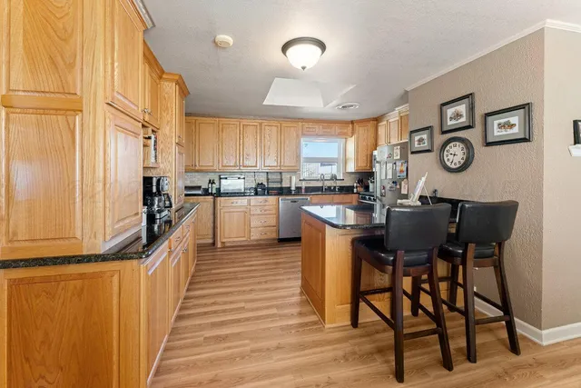 a kitchen with stainless steel appliances granite countertop a refrigerator and microwave