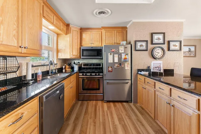 a kitchen with stainless steel appliances granite countertop a refrigerator and microwave