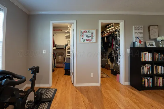 a view of a livingroom with a chandelier fan and wooden floor