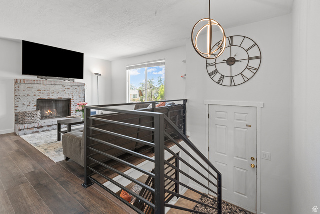 3951 Brixton Road Salt Lake City, UT 84129 - Photo 6 of 22 Living area featuring wood-finish flooring, a white-painted brick fireplace with a hearth, and a large window