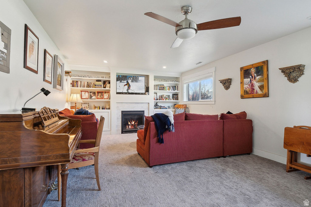 550 Pine Canyon Road Midway, UT 84049 - Photo 24 of 44 Living area featuring a fireplace with a light-colored surround, built-in shelving, a ceiling fan, recessed lighting, and a window