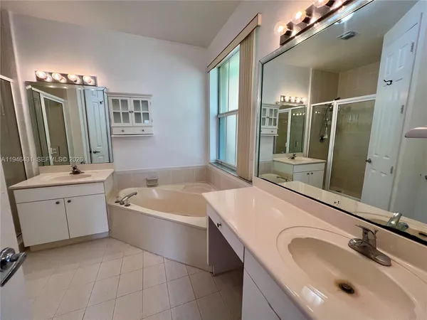 a bathroom with a tub sink and mirror