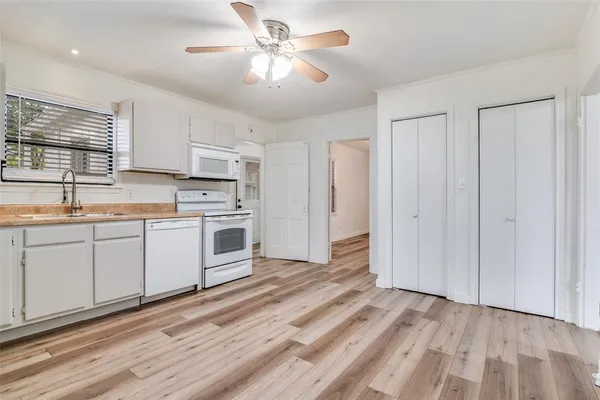 a kitchen with white cabinets and white appliances