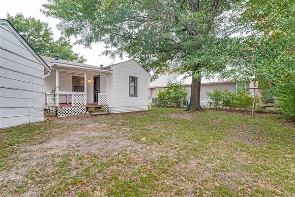 a backyard of a house with table and chairs