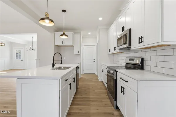 a kitchen with white cabinets sink and stove