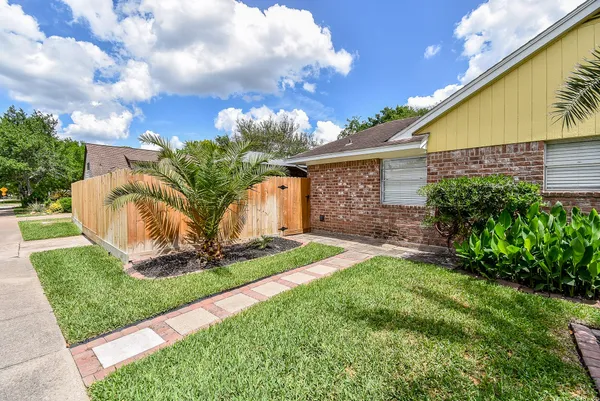 an empty room with chandelier fan and windows