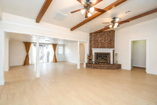 a view of a room with a ceiling fan and hardwood floor