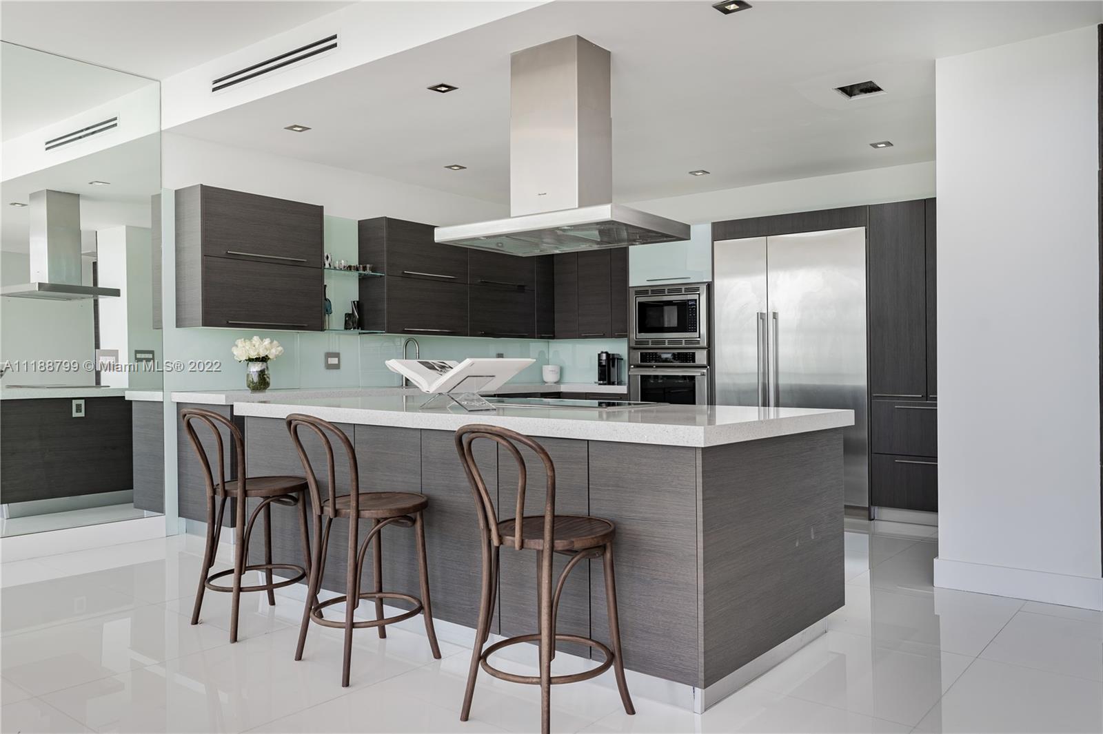 1925 Brickell Avenue, Unit DPH7 Miami, FL 33129 - Photo 8 of 37 a kitchen with a table chairs refrigerator and cabinets