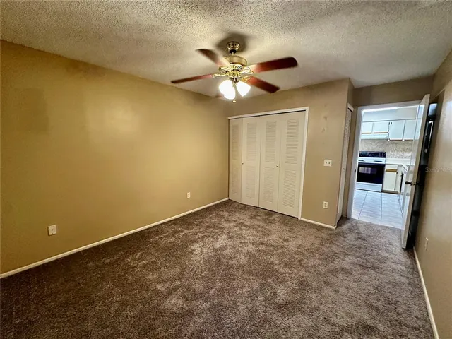 an empty room with closet and a ceiling fan