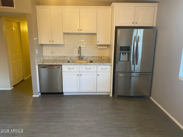 a kitchen with stainless steel appliances granite countertop a refrigerator sink and cabinets
