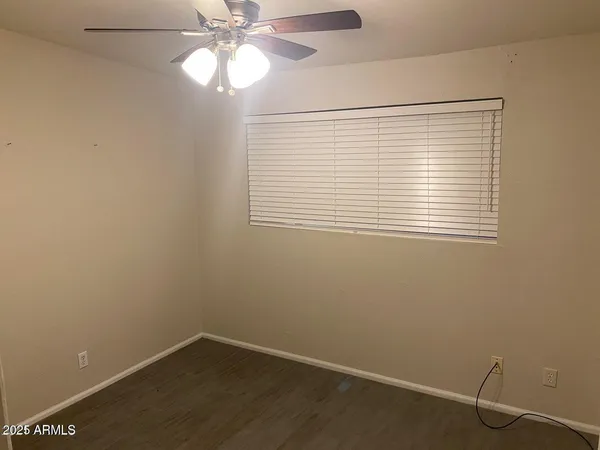 an empty room with a window and a fan