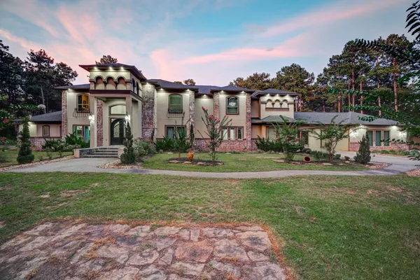 a view of a big house with a big yard and large trees