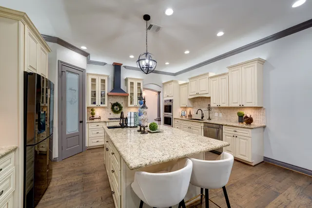 a living room with stainless steel appliances kitchen island granite countertop a sink and cabinets
