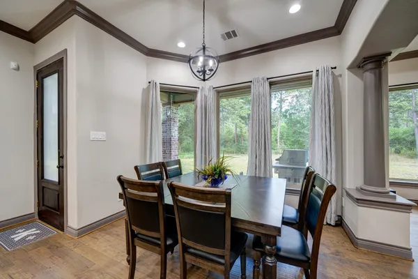 a living room with furniture kitchen view and a wooden floor