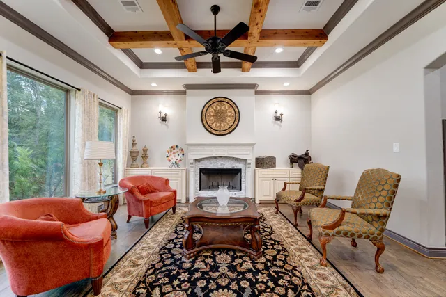 a living room with furniture a fireplace and large windows
