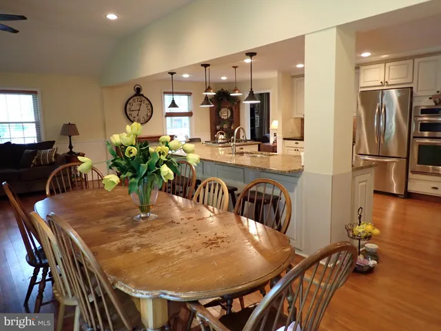 a dining room filled chandelier and wooden floor