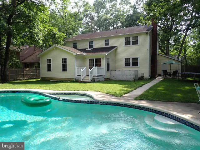 a view of a house with a yard patio and swimming pool