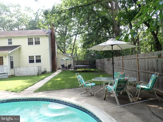 a view of backyard with swimming pool and outdoor seating