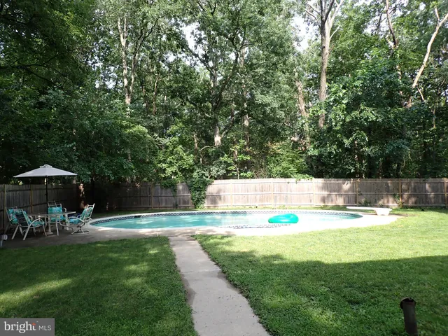 a view of a swimming pool with lawn chairs under an umbrella