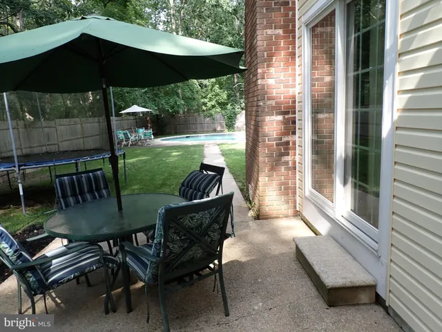 a view of a patio with a dining table and chairs under an umbrella