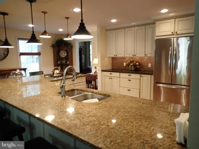 a kitchen with stainless steel appliances granite countertop a sink a stove and a refrigerator