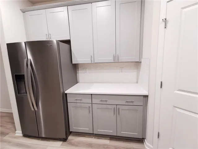 a kitchen with cabinets and a refrigerator