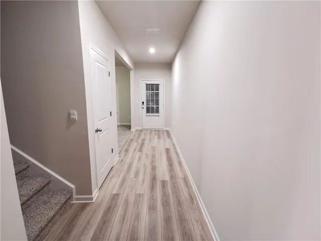 a view of a hallway with wooden floor