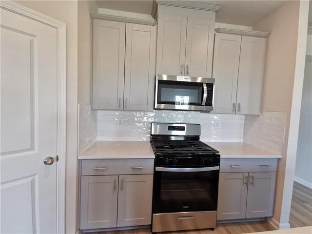 a kitchen with white cabinets and stainless steel appliances