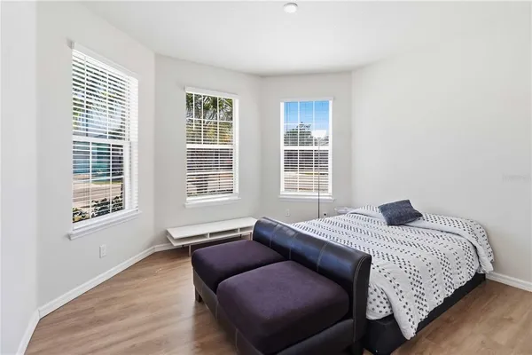 a bedroom with a bed and wooden floor