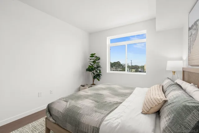 a bedroom with a bed and a potted plant