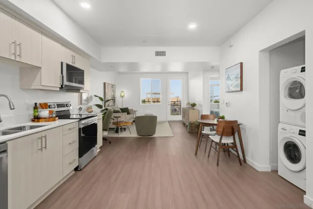 a kitchen with a dining table chairs a refrigerator and cabinets