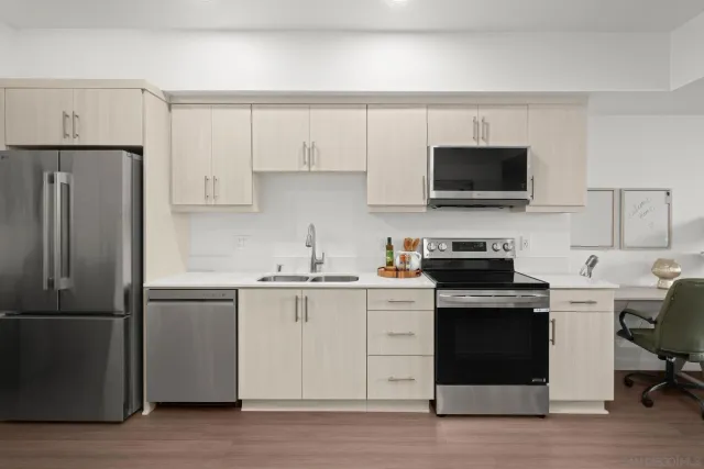 a kitchen with cabinets stainless steel appliances and a counter space