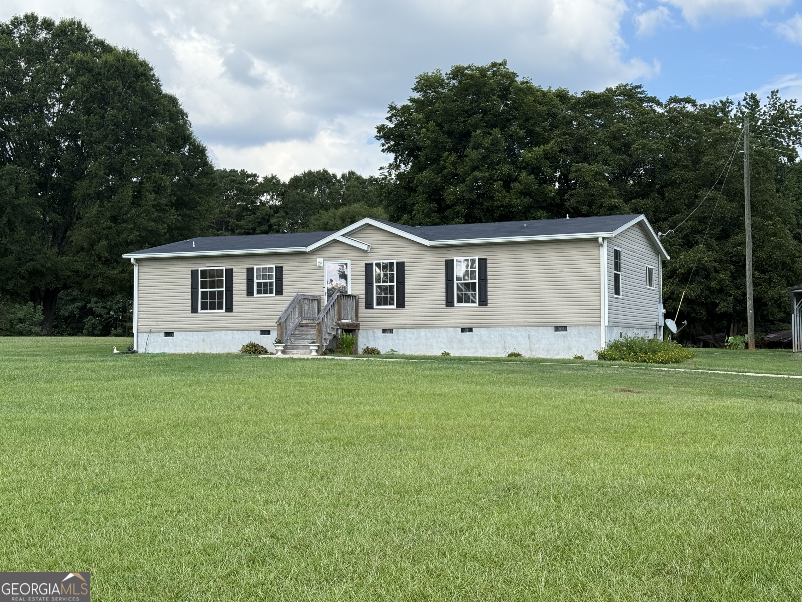 a view of a house with a big yard and potted plants